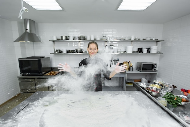 Le Chef Pâtissier Tape Dans Ses Mains Et La Farine Est éparpillée Dans Toute La Cuisine.