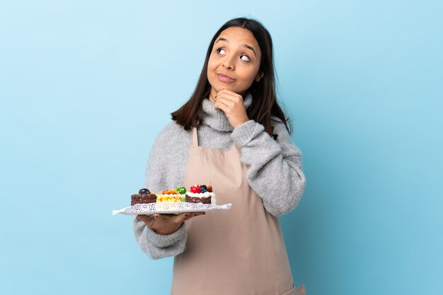 Chef pâtissier tenant une assiette avec des gâteaux