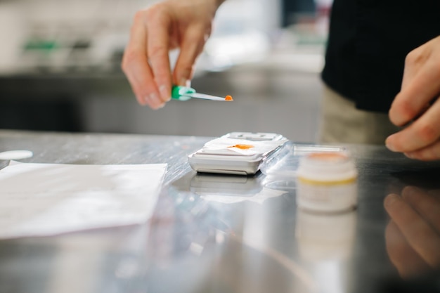 Un chef pèse le colorant alimentaire pour les macarons ou autres desserts Close up