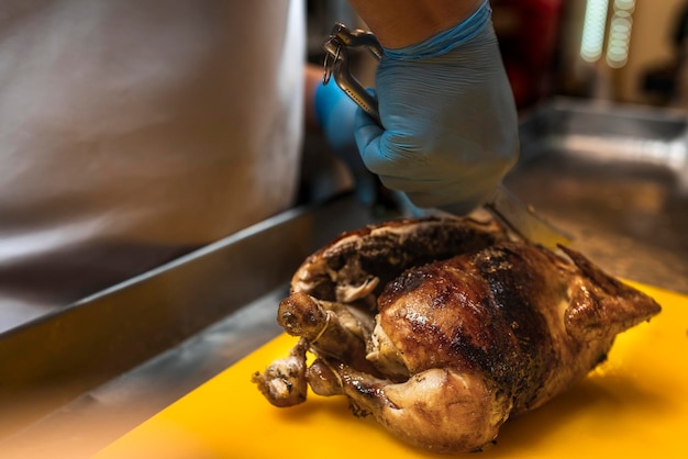 Chef préparant un poulet fraîchement rôti dans le gril d'un restaurant