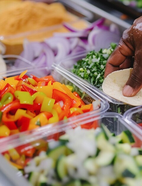 Photo chef préparant des tacos traditionnels mexicains avec des ingrédients frais dans des récipients dans la cuisine de la maison