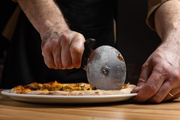 le chef prépare de délicieuses pizzas au restaurant. Fermer