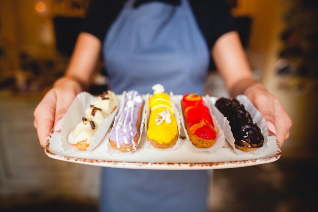 Photo le chef a préparé de délicieux éclairs sur le plateau