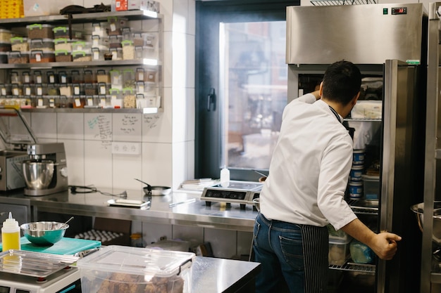 Le chef prépare la nourriture dans la cuisine spacieuse et moderne