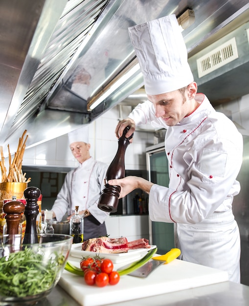 Le Chef Prépare Un Plat Dans La Cuisine Du Restoran.