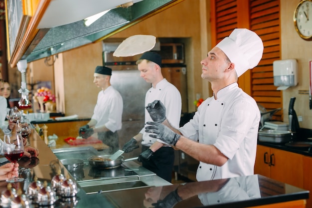 Le Chef Prépare Des Plats Devant Les Visiteurs Au Restaurant