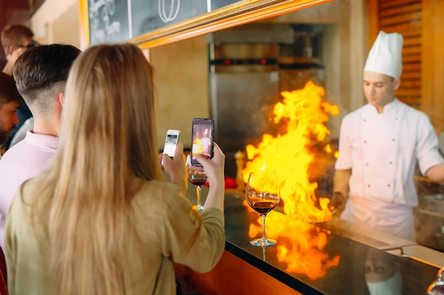 Le chef prépare des plats devant les visiteurs au restaurant