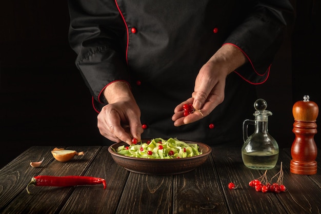 Le chef prépare une salade pour le petit déjeuner ou le déjeuner dans la cuisine