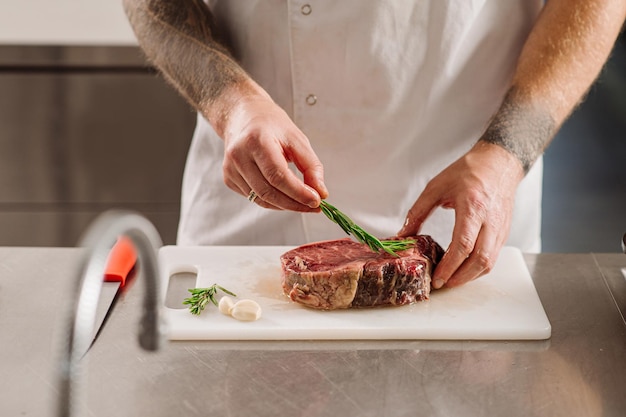 Le chef prépare un steak à frire dans la cuisine du restaurant