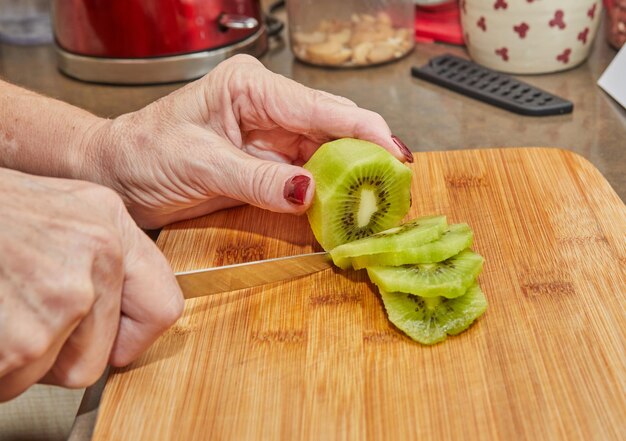 Le chef prépare la tarte au kiwi couper le kiwi en tranches