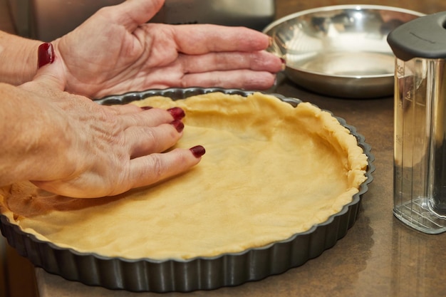 Le chef prépare la tarte et met la pâte dans le moule