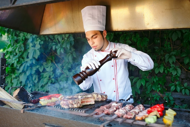 Le chef prépare la viande au barbecue.