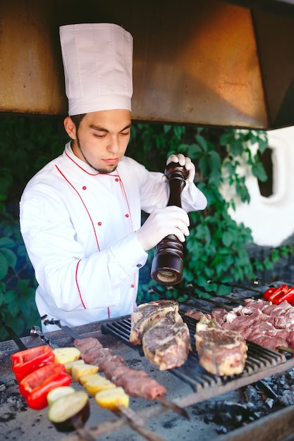 Le chef prépare la viande au barbecue.