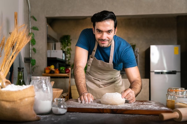 Chef professionnel battre la poudre blanche de farine sur une table en bois pour un gâteau au dessert sucré et une pizza italienne dans la cuisine du restaurant pour un délicieux dîner spécial