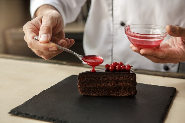 Chef professionnel d'homme mûr faisant cuire le repas à l'intérieur