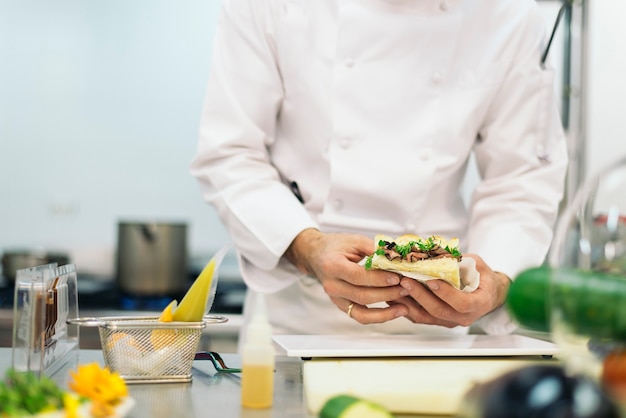 Photo chef professionnel masculin cuisinant dans une cuisine.