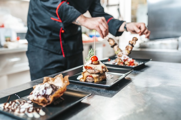 Chef professionnel organisant une assiette de nourriture avec de la viande et des légumes