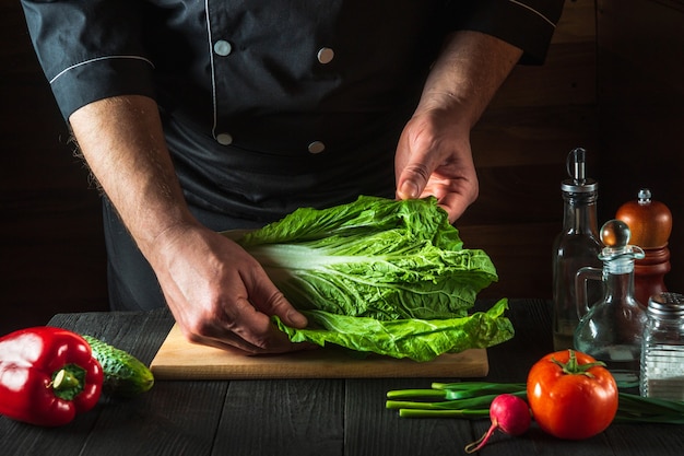 Un chef professionnel prépare une salade de chou napa fraîche. Préparation pour le tranchage dans la cuisine du restaurant. Idée de régime végétal.