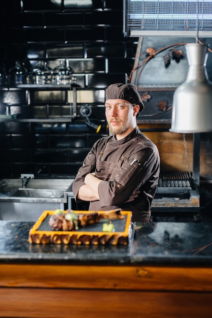 Un chef professionnel sert magnifiquement un steak grillé juteux avec du beurre et des assaisonnements