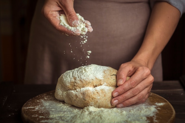 Chef professionnel versez la farine sur la pâte.