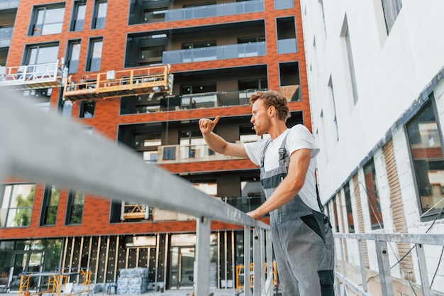 Chef de projet Jeune homme travaillant en uniforme à la construction pendant la journée