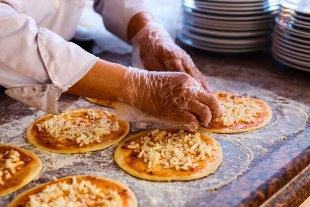 Le chef, qui met des garnitures sur une pizza