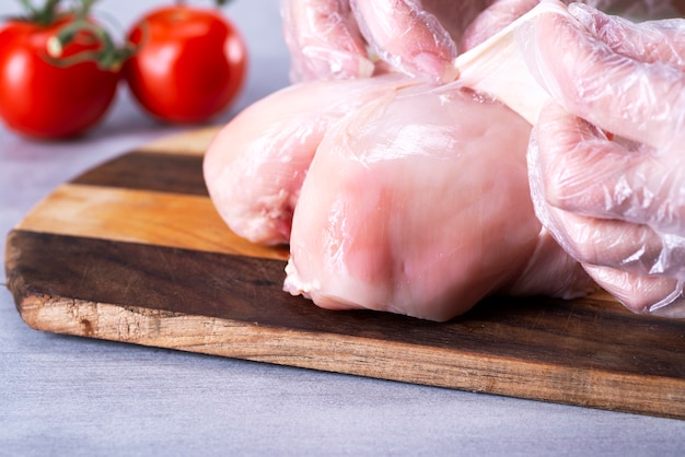 Le chef retire la peau de la poitrine de poulet pour réduire la quantité de graisse dans les aliments