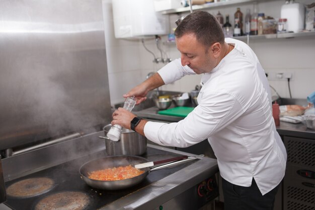 Chef salant les légumes à la poêle, copiez l'espace