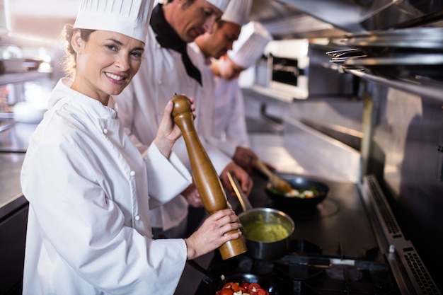 Chef saupoudrant de poivron sur tomates