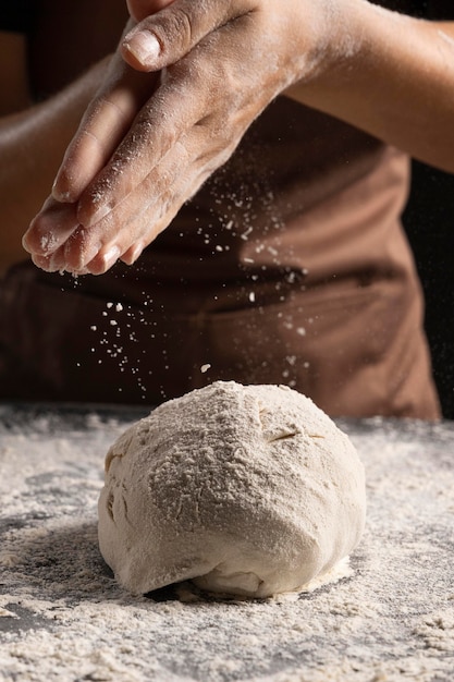 Photo chef saupoudrer de farine sur une goutte de pâte