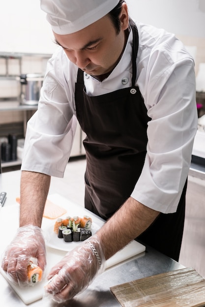 Chef servant des sushis sur une assiette. Cuisine japonaise traditionnelle dans des restaurants modernes