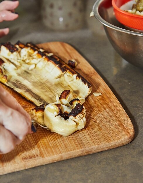 Le chef sort la pulpe d'une aubergine cuite au four