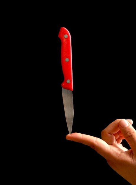 Chef sosteniendo cuchillo con la mano. Cuchillo rouge. Hobre sosteniendo cuchillo con el dedo. fondo