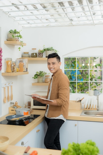 Chef souriant et confiant debout dans la cuisine