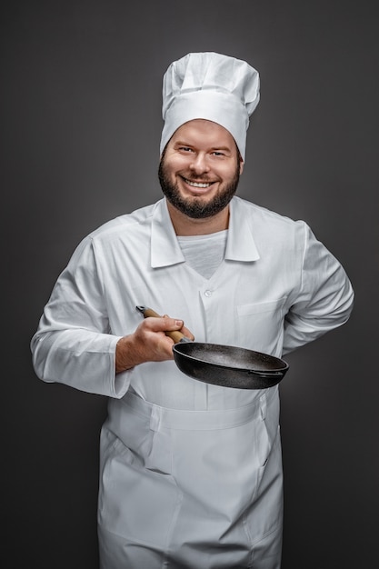 Chef souriant avec poêle vide