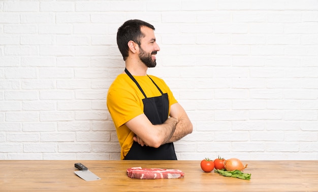 Chef tenant dans une cuisine en position latérale