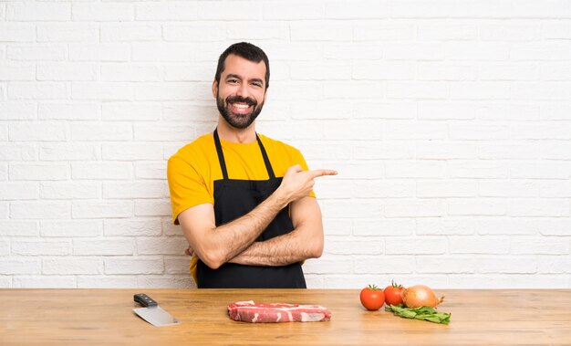 Chef tenant un doigt de cuisine pointant sur le côté