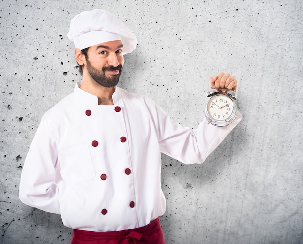 Chef tenant une horloge sur fond blanc