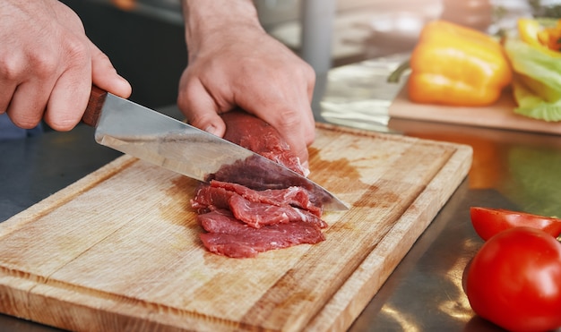 Chef toujours frais jamais congelé préparant un plat dans une cuisine commerciale en gros plan