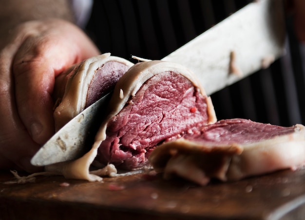 Un chef travaillant sur le découpage d&#39;un morceau de recette de photographie de steak food