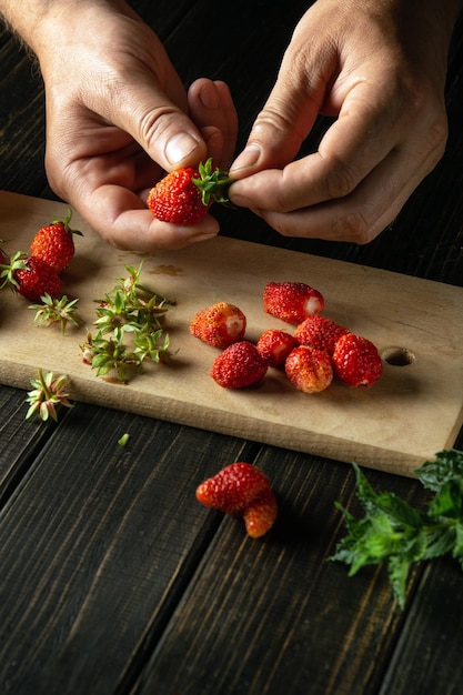 Le chef trie les fraises fraîches avant de préparer une boisson fraîche