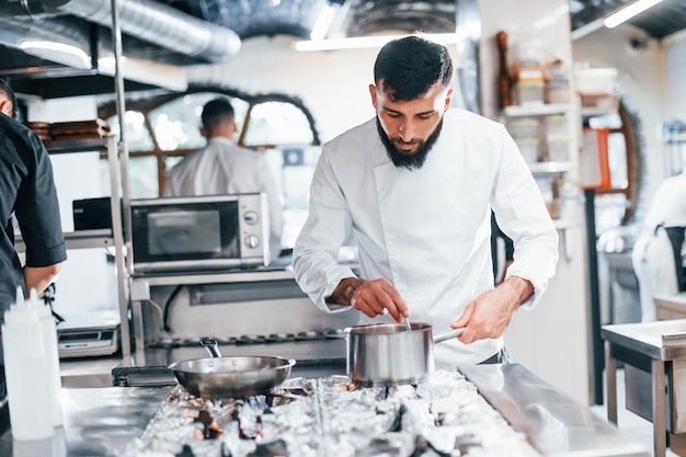 Chef en uniforme blanc cuisiner des aliments à la cuisine Journée bien remplie au travail