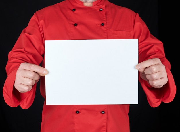 Chef en uniforme rouge tenant une feuille de papier vierge