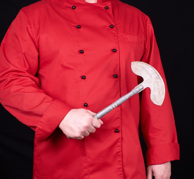 Photo chef en uniforme rouge tenant un vieux couteau en métal pour la viande et les légumes