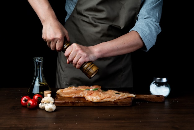 Chef, verser le poivre sur la poitrine de poulet