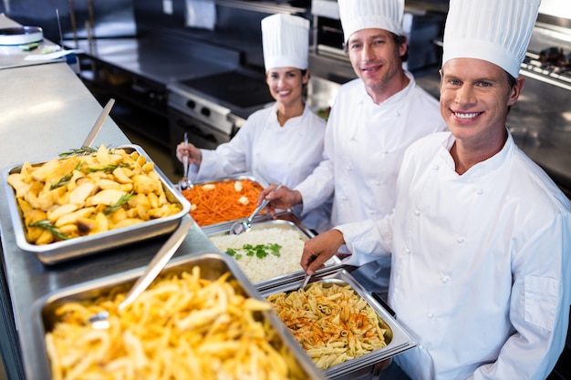 Chefs debout sur des plateaux de pâtes