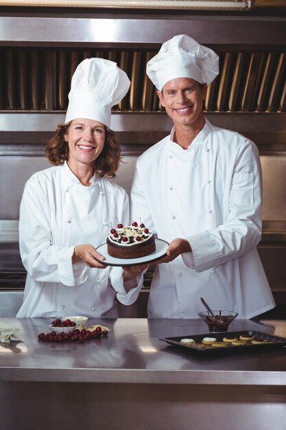 Chefs présentant le gâteau qu'ils viennent de faire