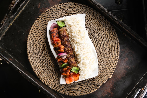 Chelo kabab ou chello kebab avec du poulet tikka et du riz servi dans un plat isolé sur une vue de dessus de tapis rouge sur la table de la nourriture arabe