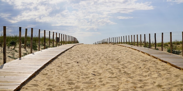 Chemin en bois accès à la côte avec entrée de vagues de plage de sable à l'océan atlantique au cap-ferret france