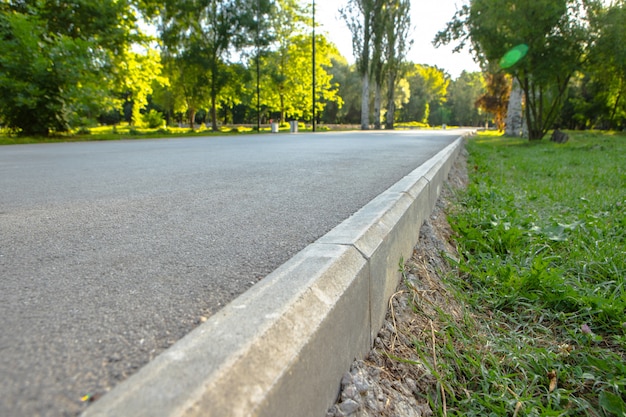 Le chemin dans le parc de la ville avec des arbres et de l'herbe